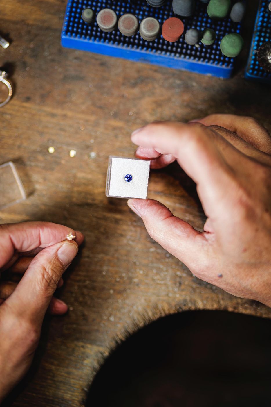 Choosing a loose round blue sapphire over the workbench at Annie Smith, Stockbridge