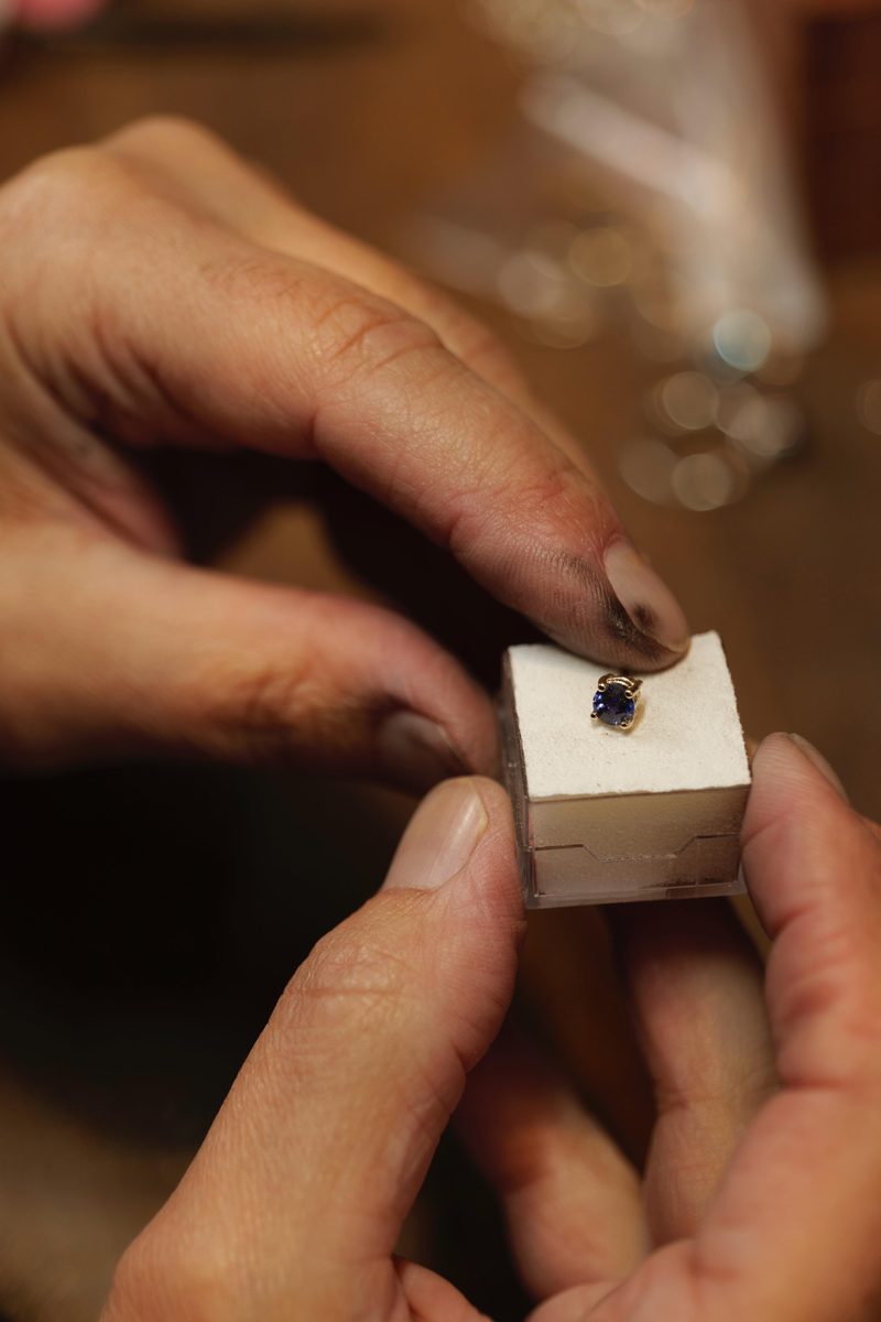 A round sapphire claw-set in gold, boxed for collection.